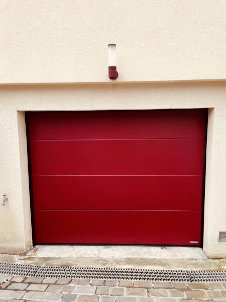 Installation d'une porte de garage sectionnelle plafond de couleur rouge